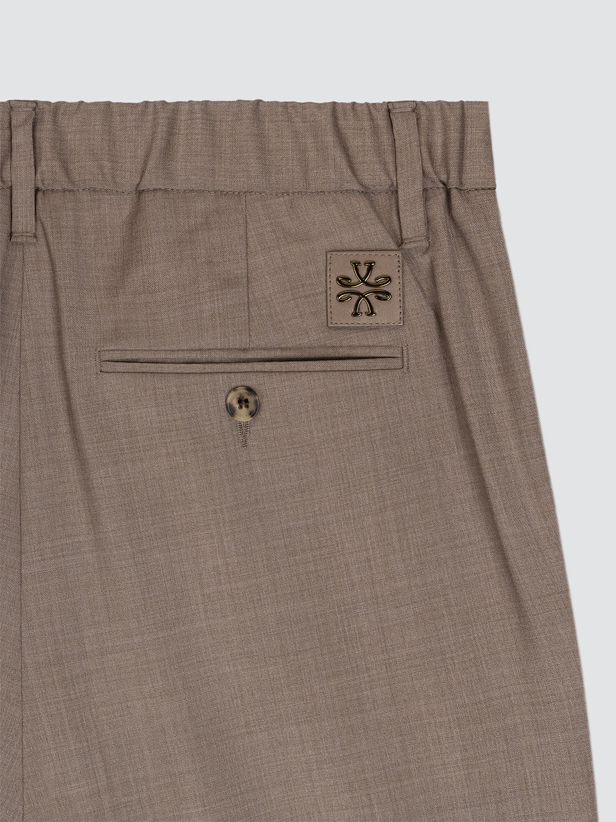 Brown pants with a logo on the pocket against a white background