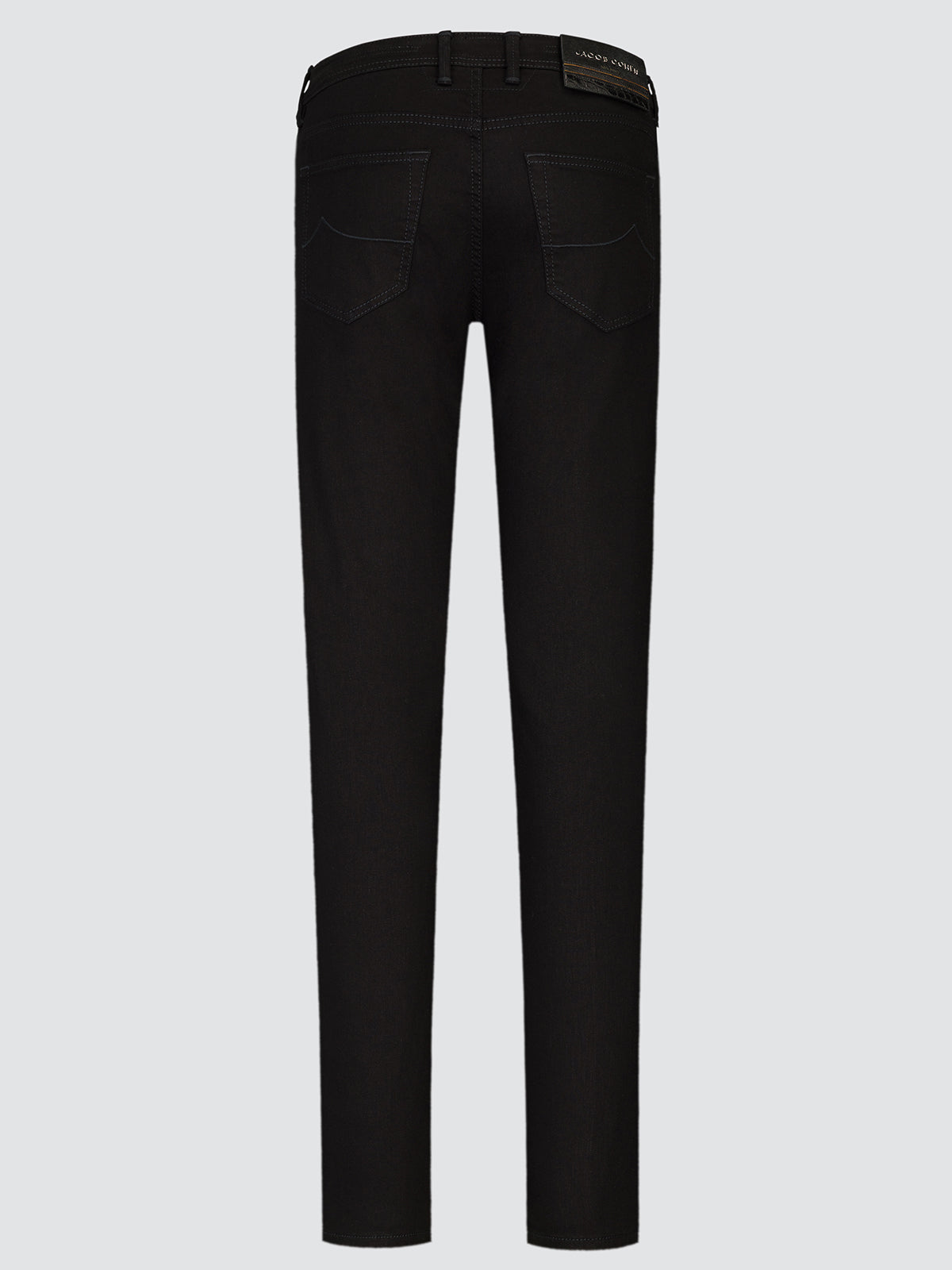 Black slim-fit jeans shown from the back, featuring a dark leather brand patch on the back waistband, photographed against a solid light gray background.