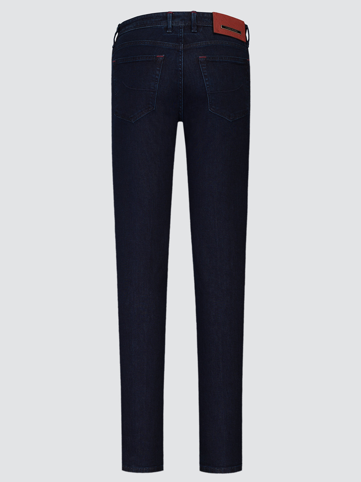 Back view of dark navy blue slim-fit jeans with a brown leather brand patch on the waistband, shown against a light gray background.