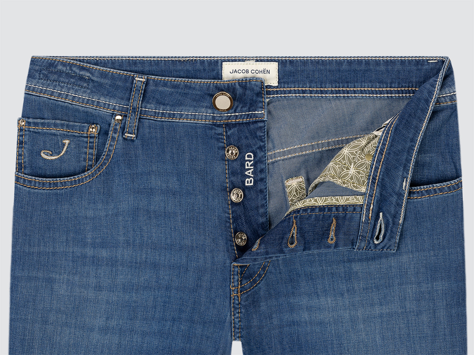 Close-up of blue jeans with visible branding on a light gray background