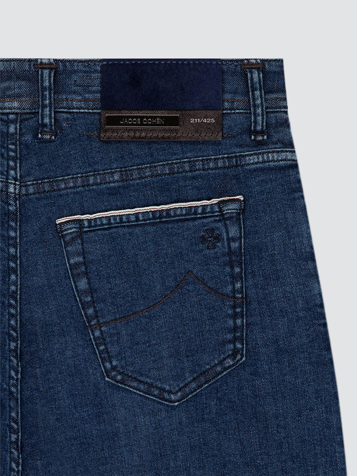Close-up of dark blue denim pants 5 pockets Jacob Cohën limited edition with a pocket detail on a white background