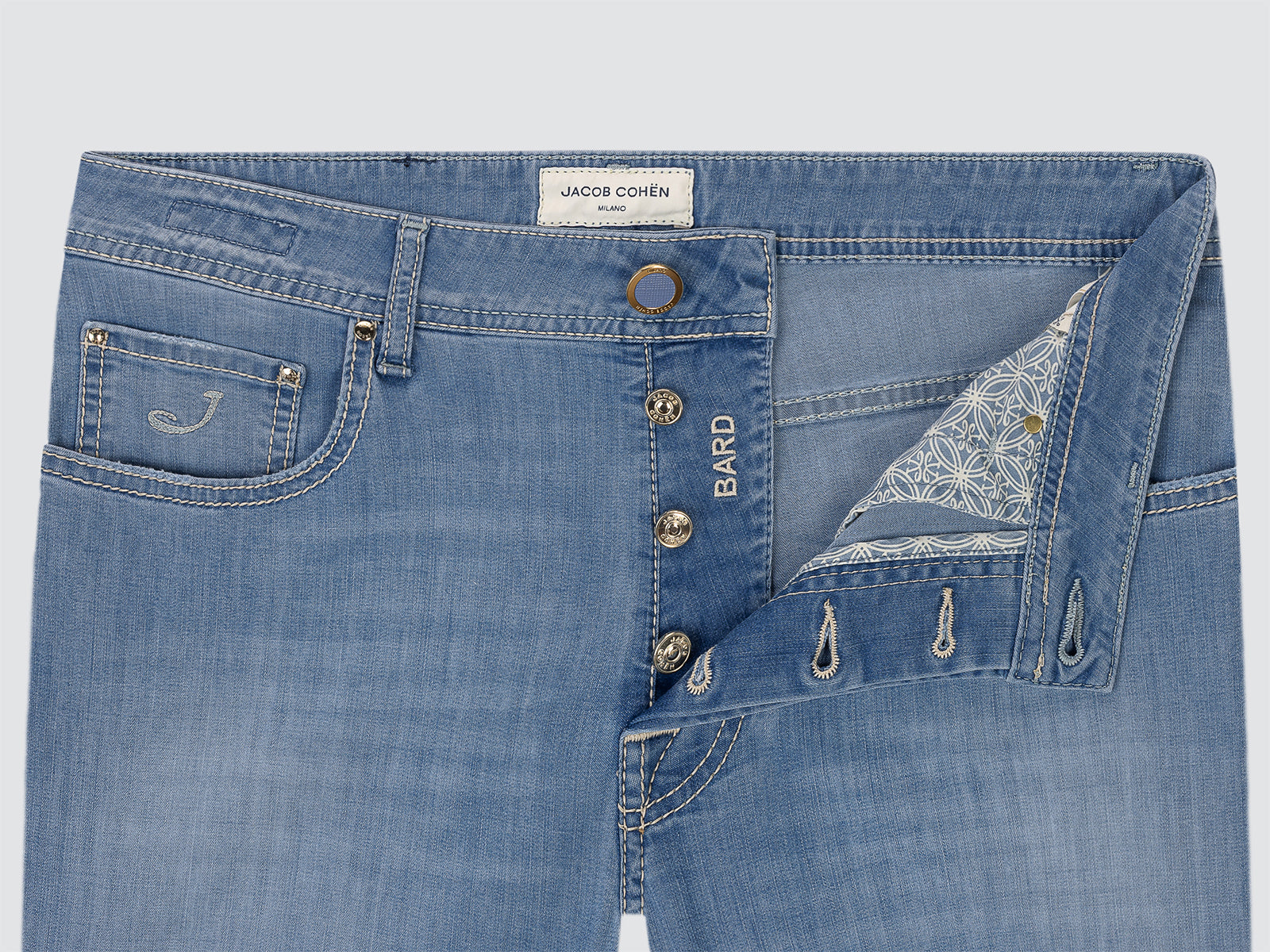 Close-up of blue jeans with visible branding on a light gray background