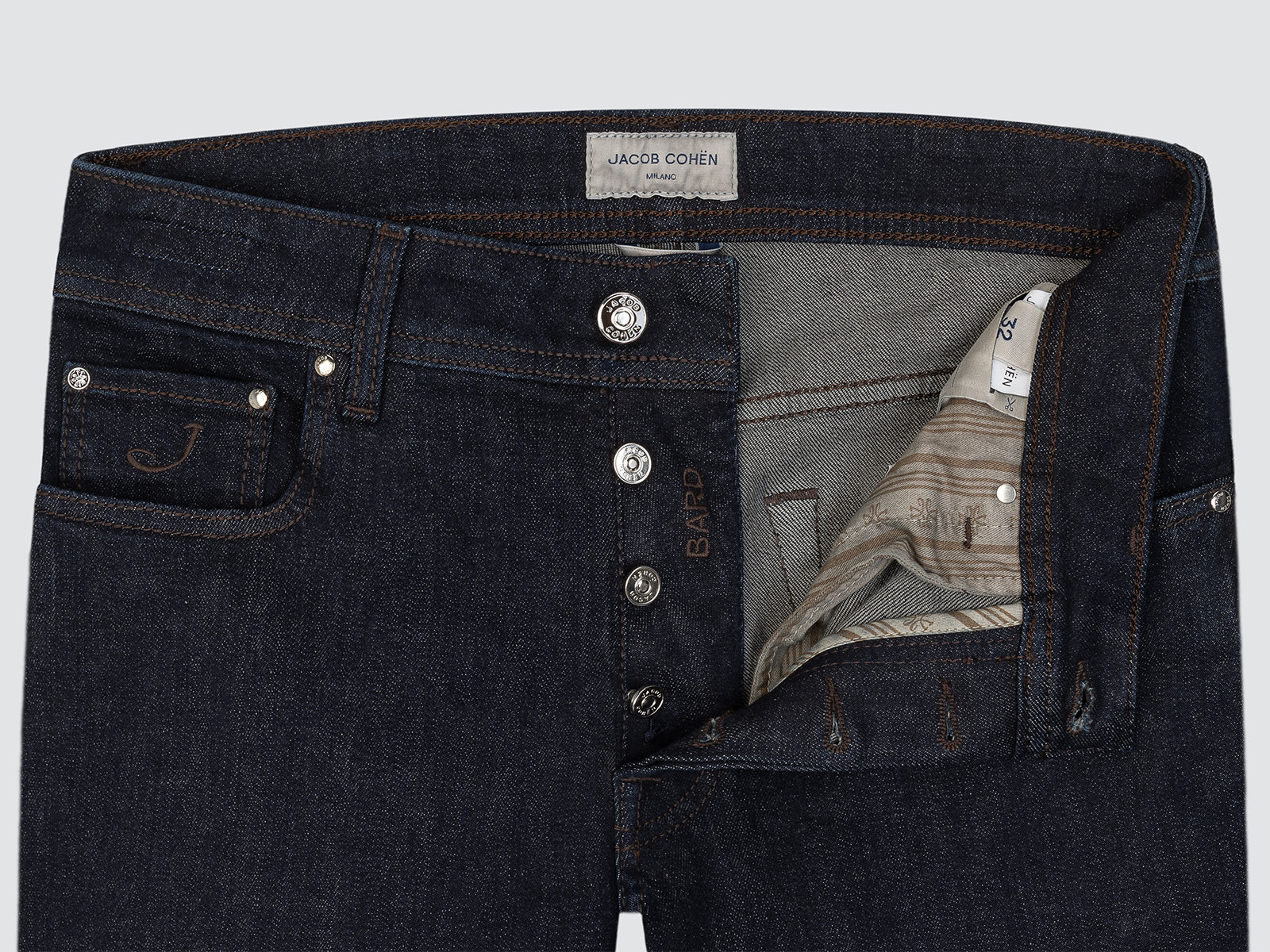 Dark denim jeans with visible brand label on a light gray background
