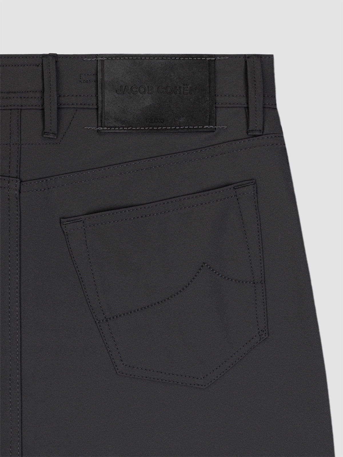 Close-up of Dark grey 5 pockets microfiber with a visible brand label on a light gray background