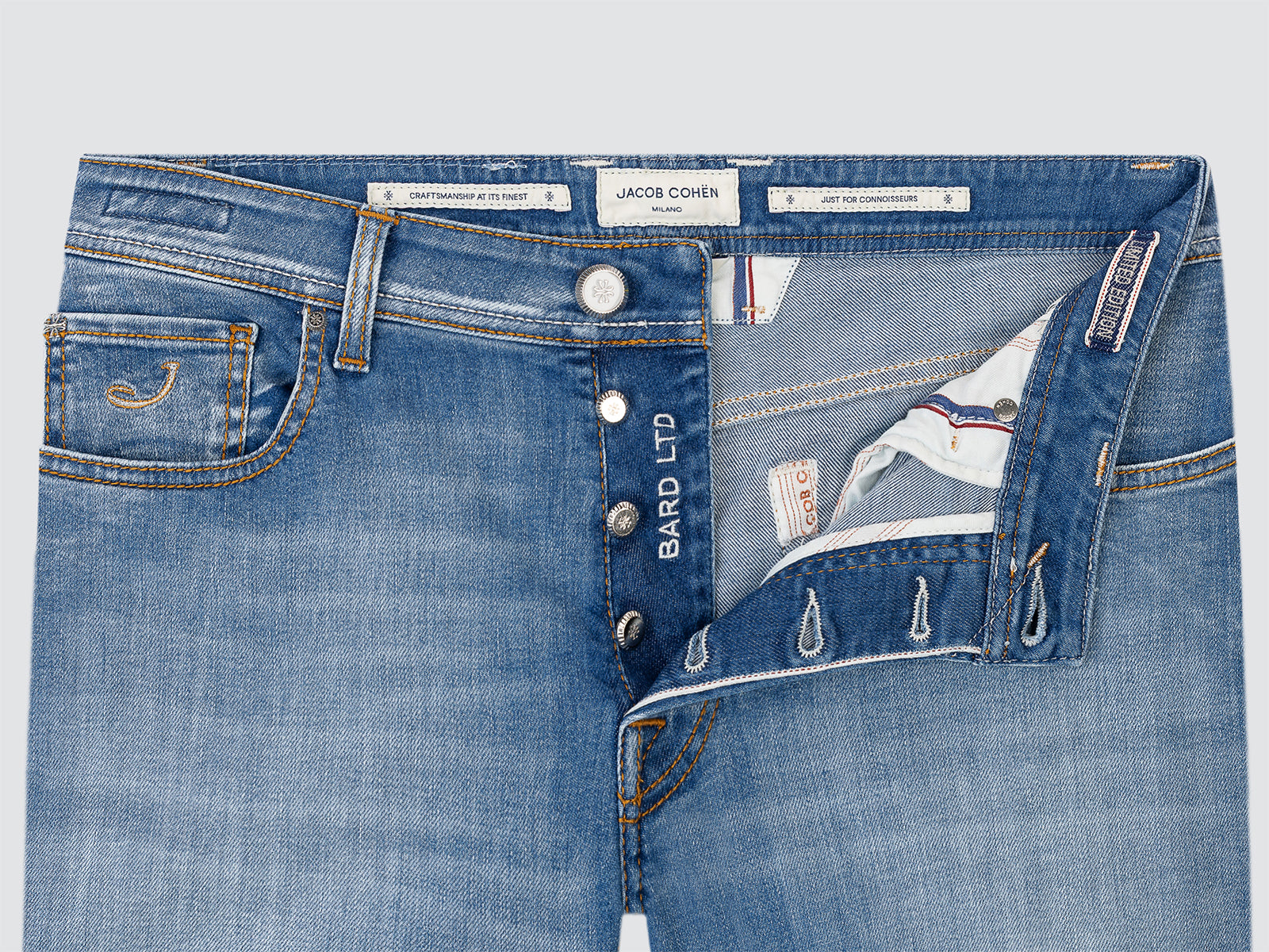 Close-up of blue jeans with visible branding and buttons Rolex on a light gray background