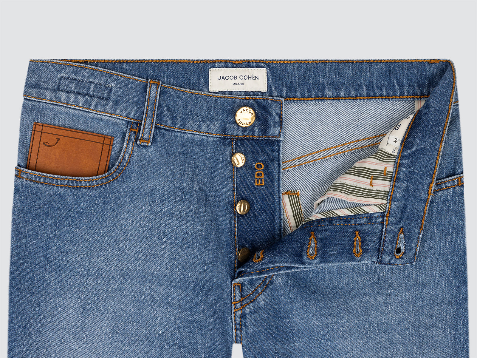 Close-up of blue jeans Edo by Jacob Cohen leather pocket on a light gray background