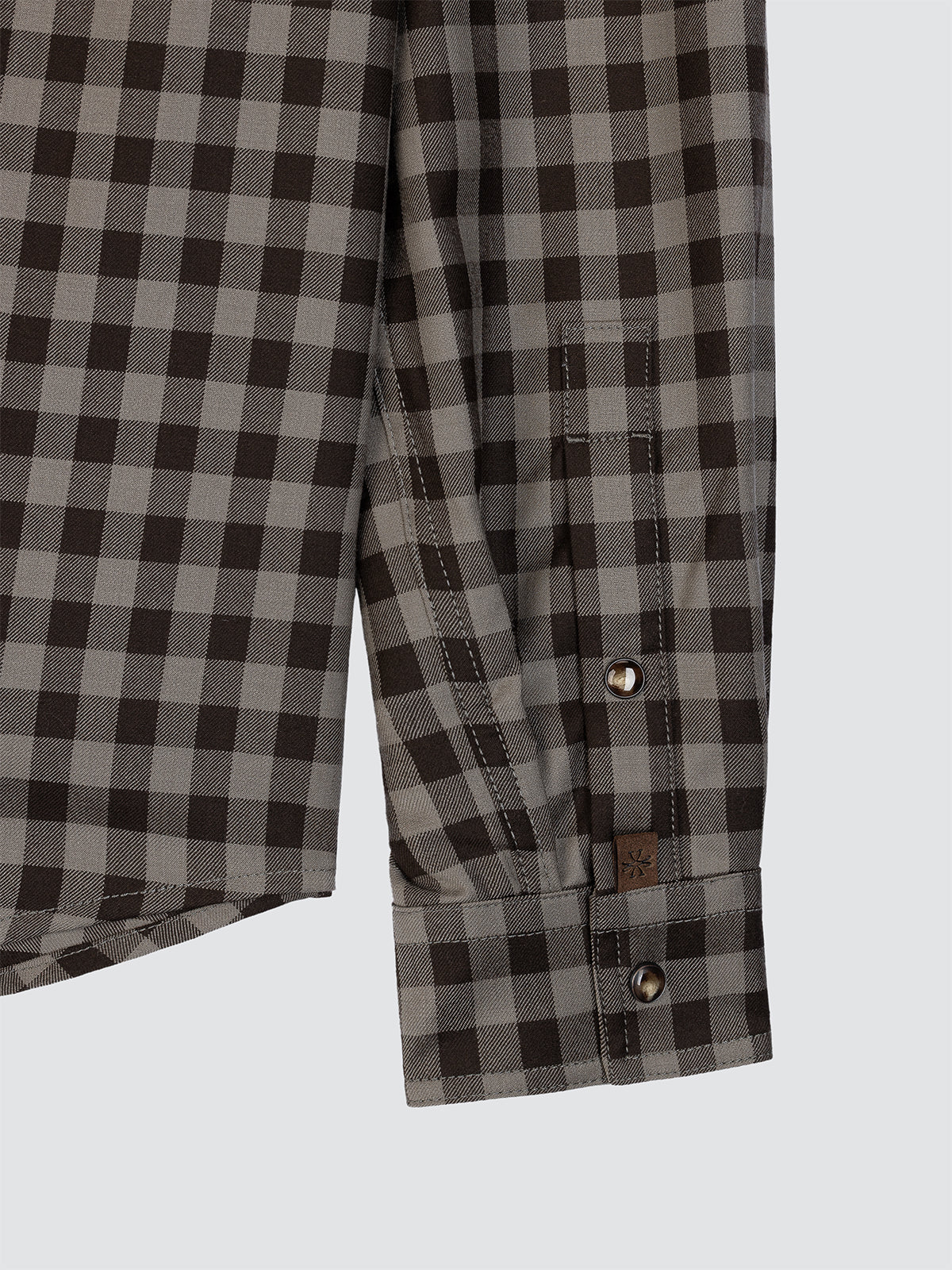 Close-up of a gray and black checkered shirt with button details on a light gray background