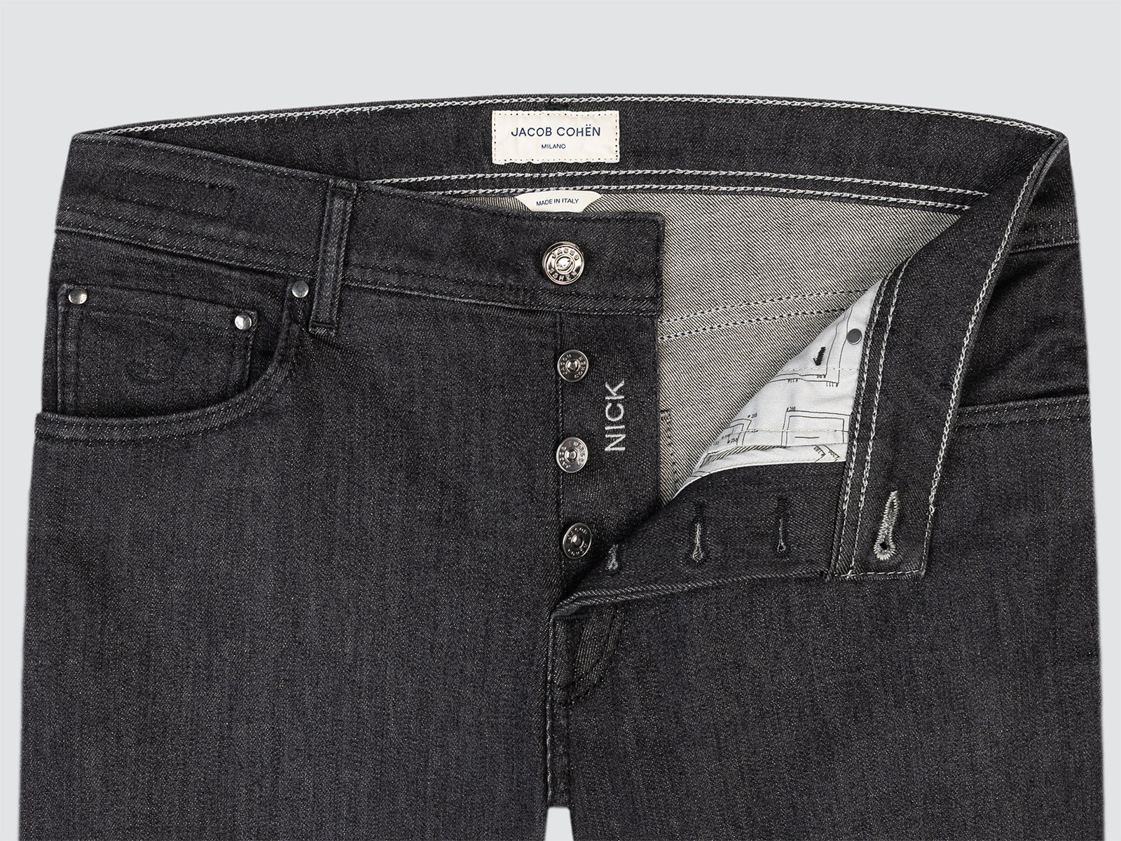 Close-up of black jeans model nick with visible branding on a light gray background