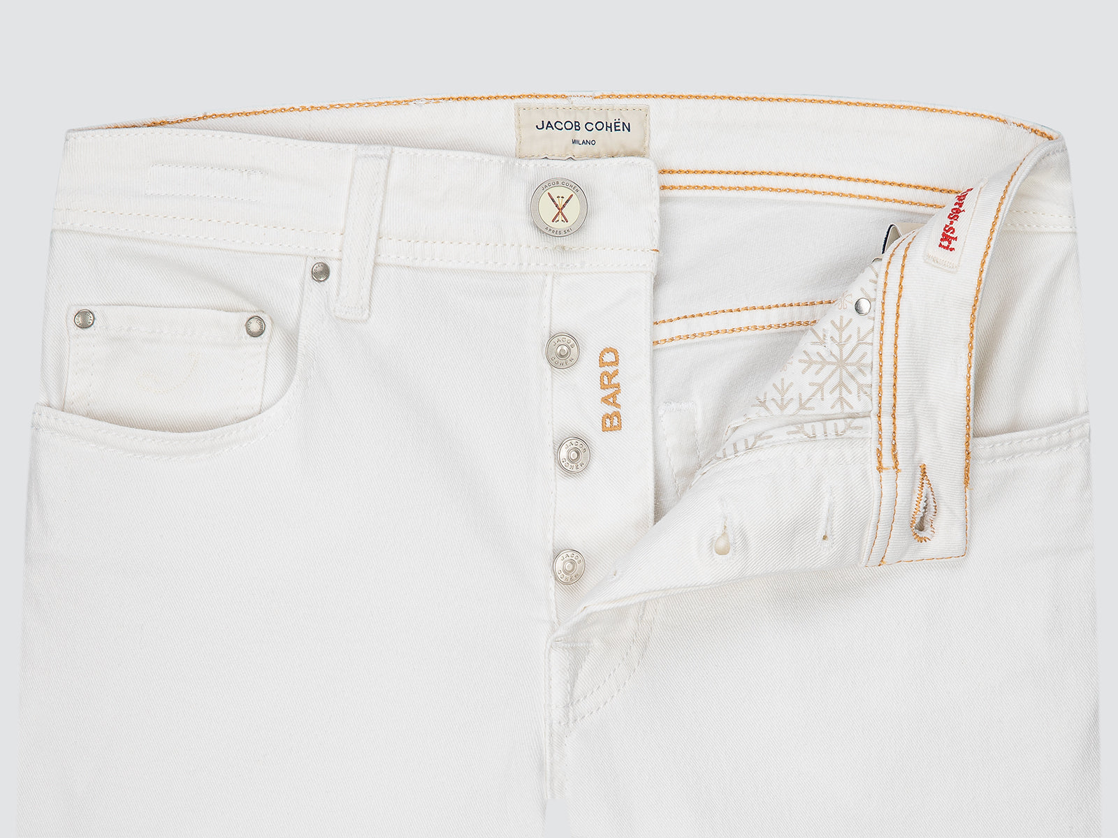 Close-up of white jeans with visible branding on a light gray background