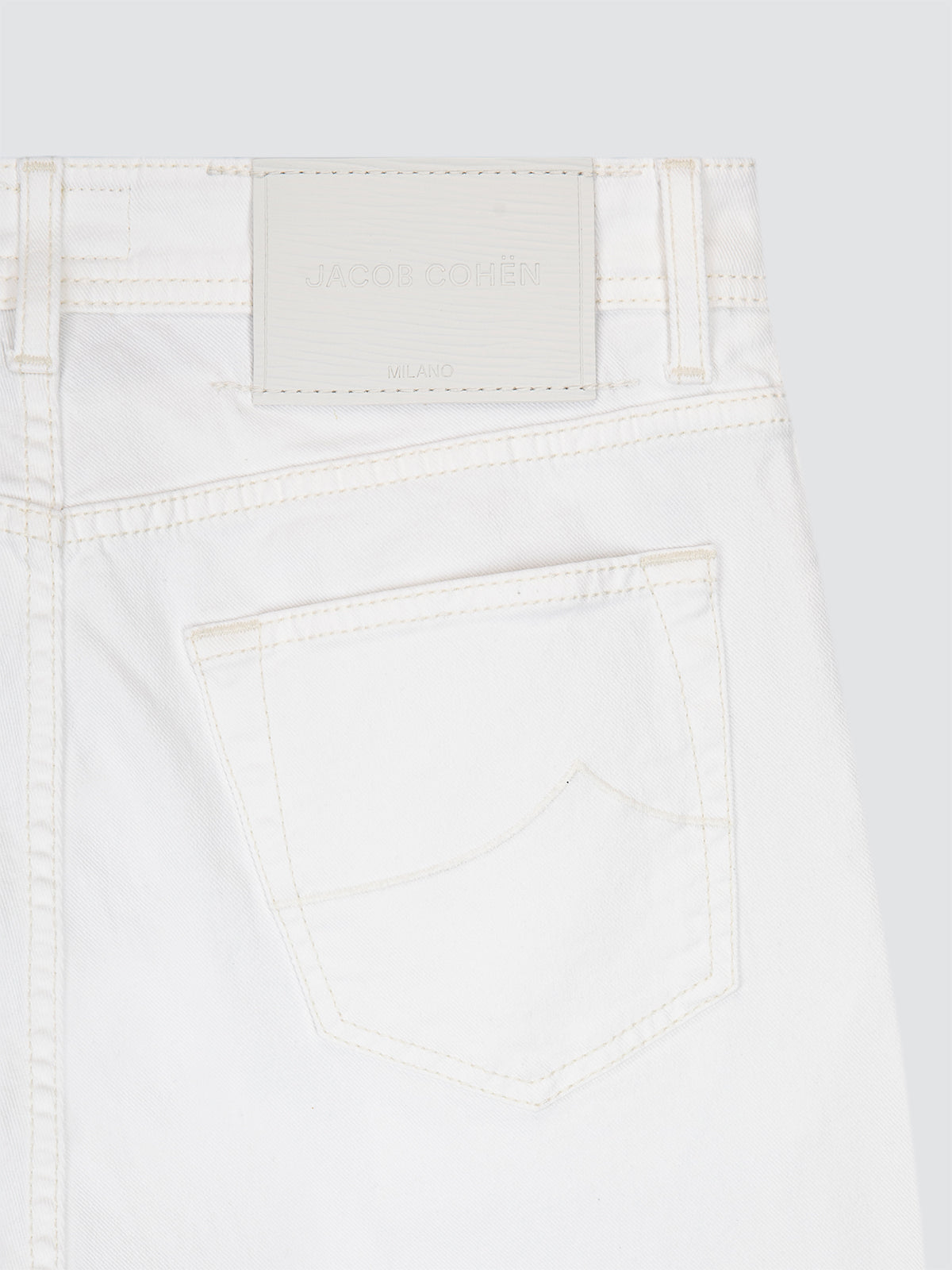 Close-up of white jeans with a plain background