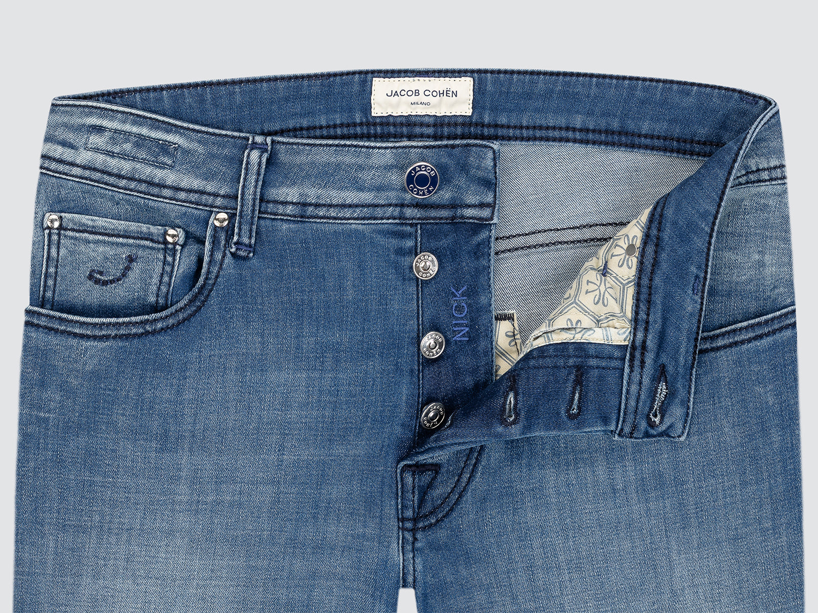 Close-up of blue jeans with visible branding on a light gray background