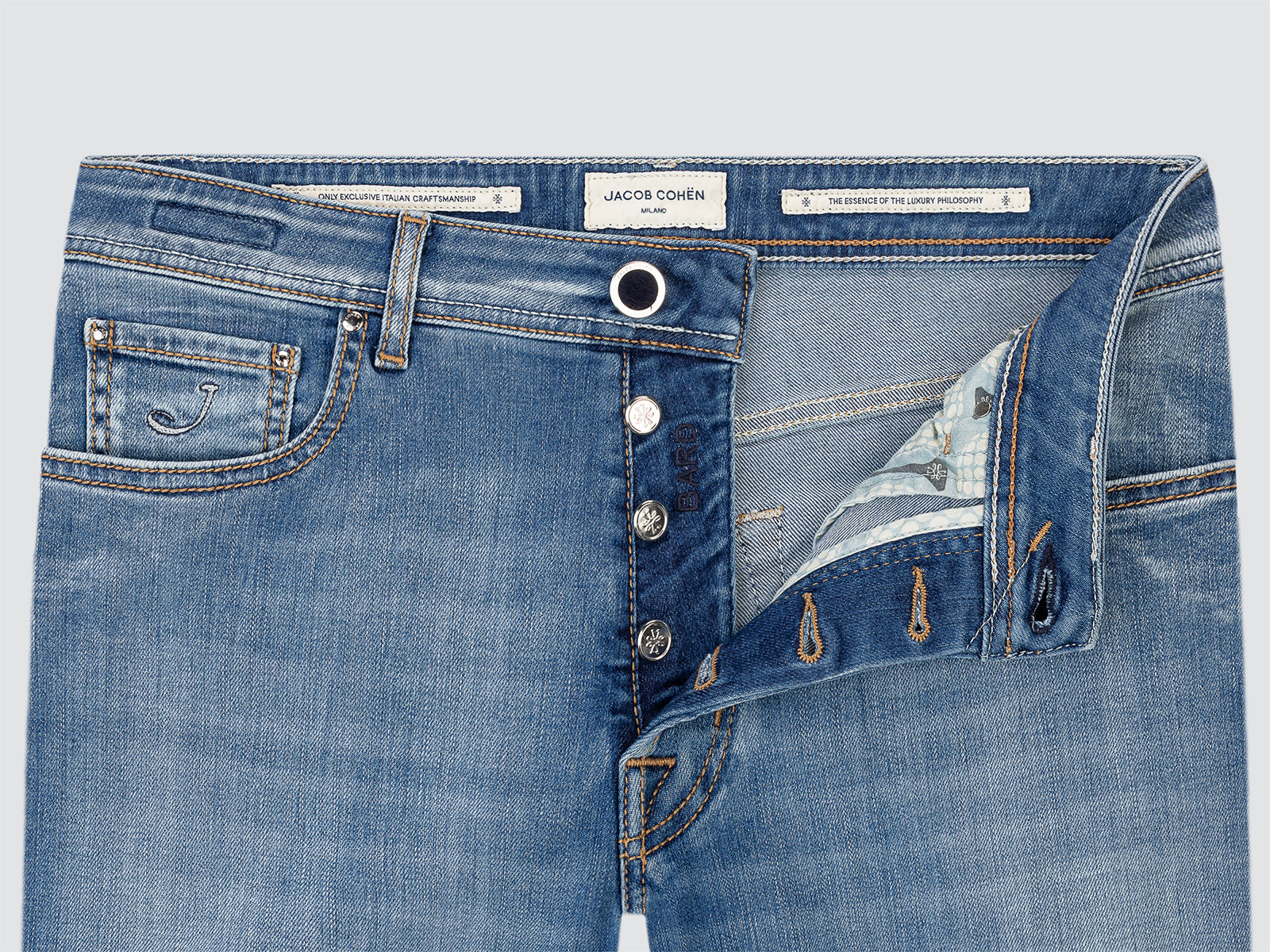 Close-up of blue jeans with brand label on a light gray background