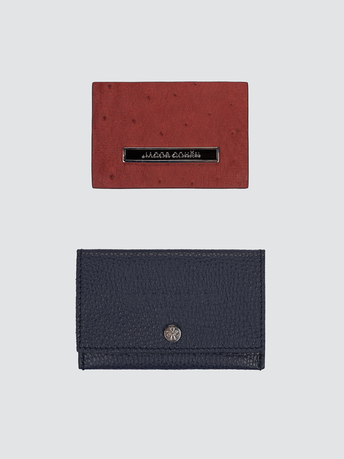 Two leather austruch back patch, one in reddish-brown ostrich leather and one in navy blue pebbled leather, displayed on a light gray background. Jacob Cohen luxury