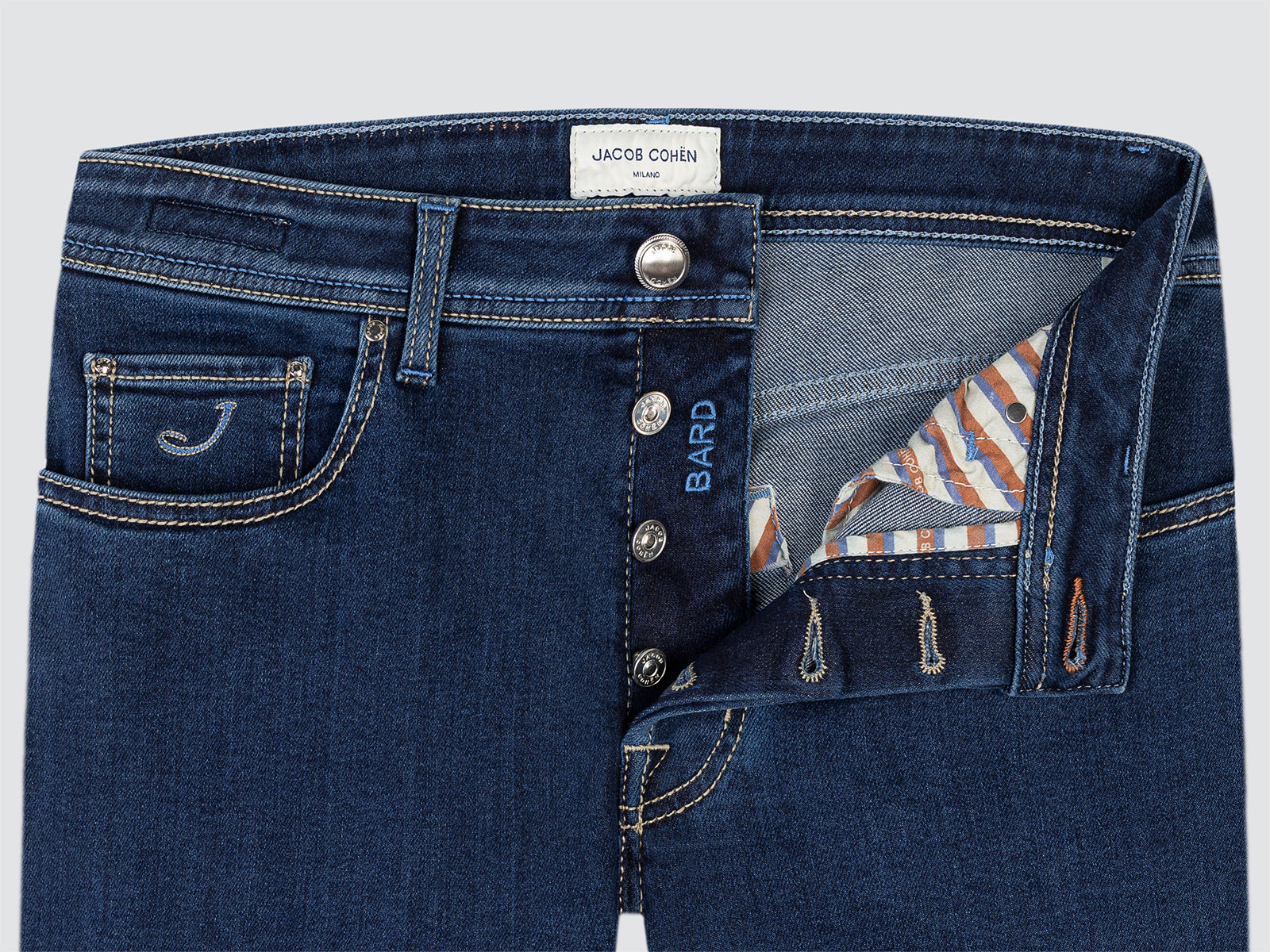 Close-up of blue jeans with visible branding on a light gray background