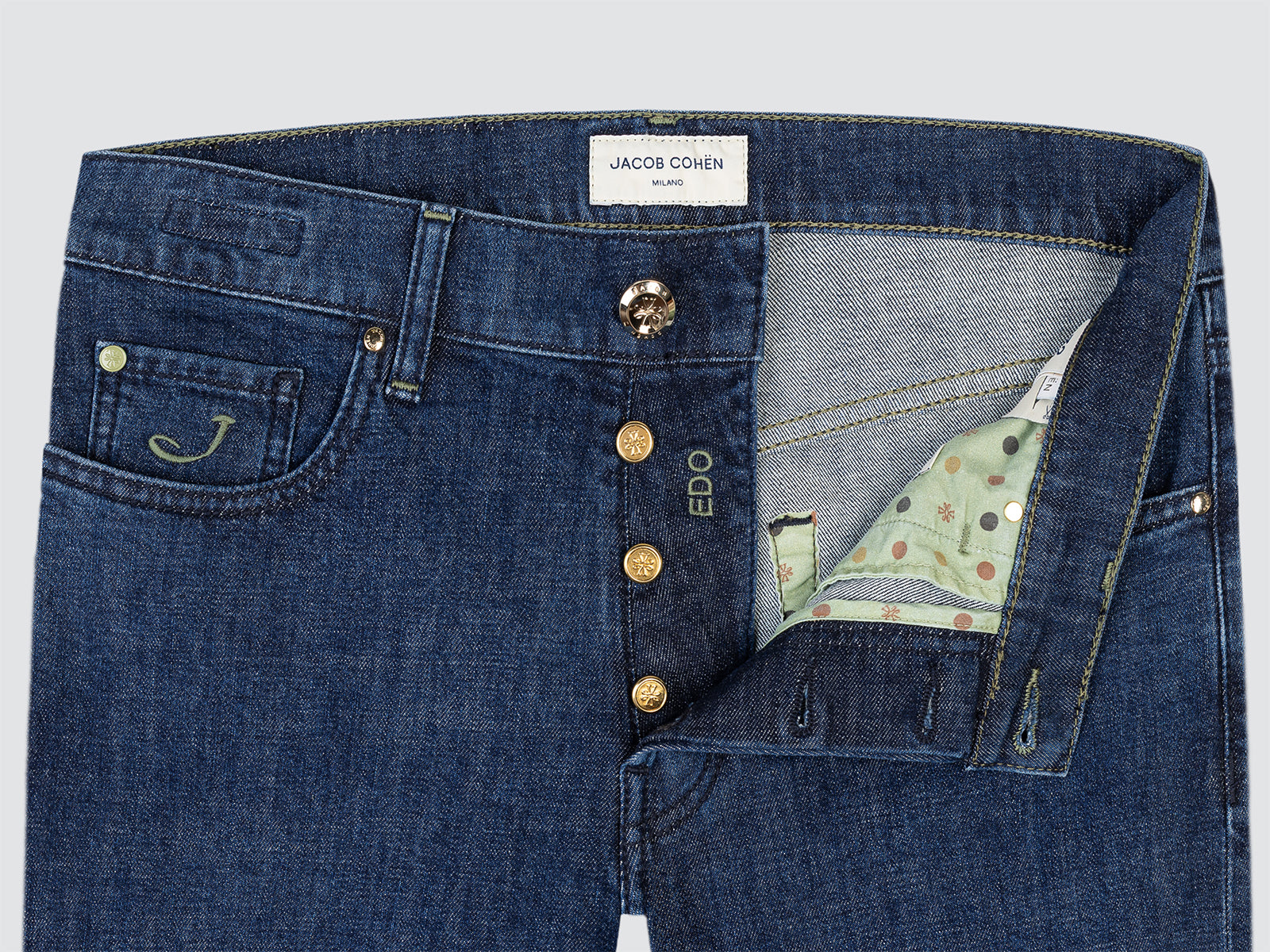 Blue jeans with a brand label and button details on a light gray background