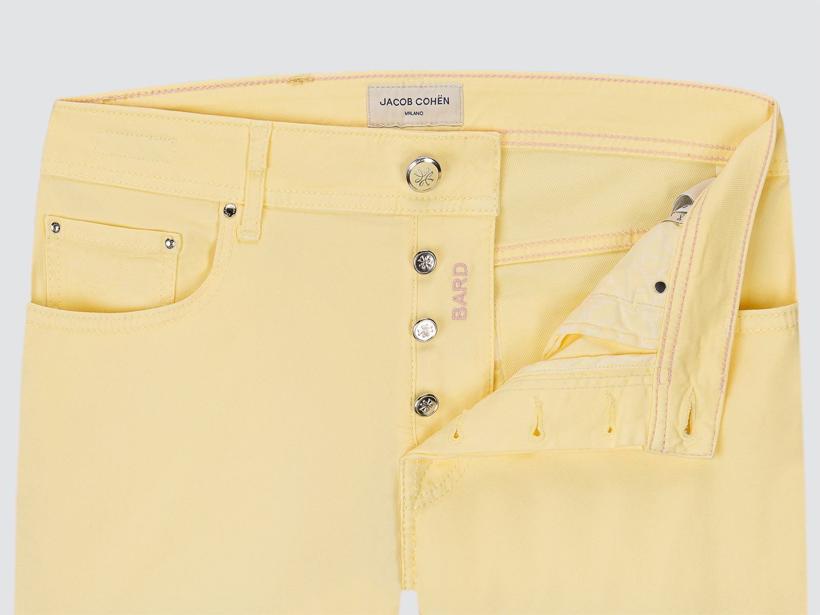 Yellow jeans with brand label on a light gray background