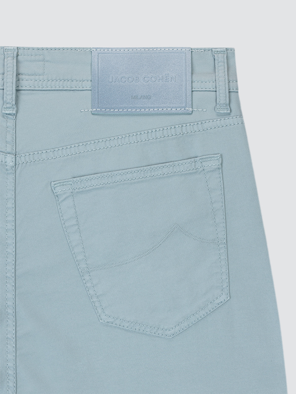 Light blue pants with a visible brand label Jacob Cohen on a light gray background