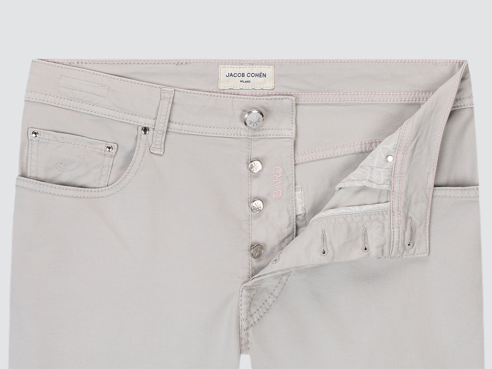 Light gray pants with button details on a white background, featuring the brand 'Jacob Cohen'.