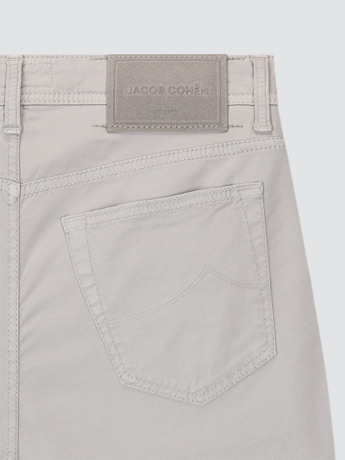 Close-up of light gray pants Jacob Cohen with a brand label on a white background