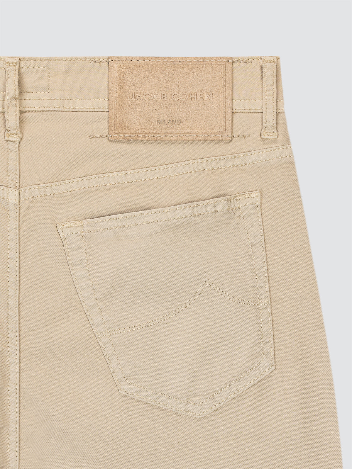 Beige pants 5 pockets with a brand label Jacob Cohen on a light gray background