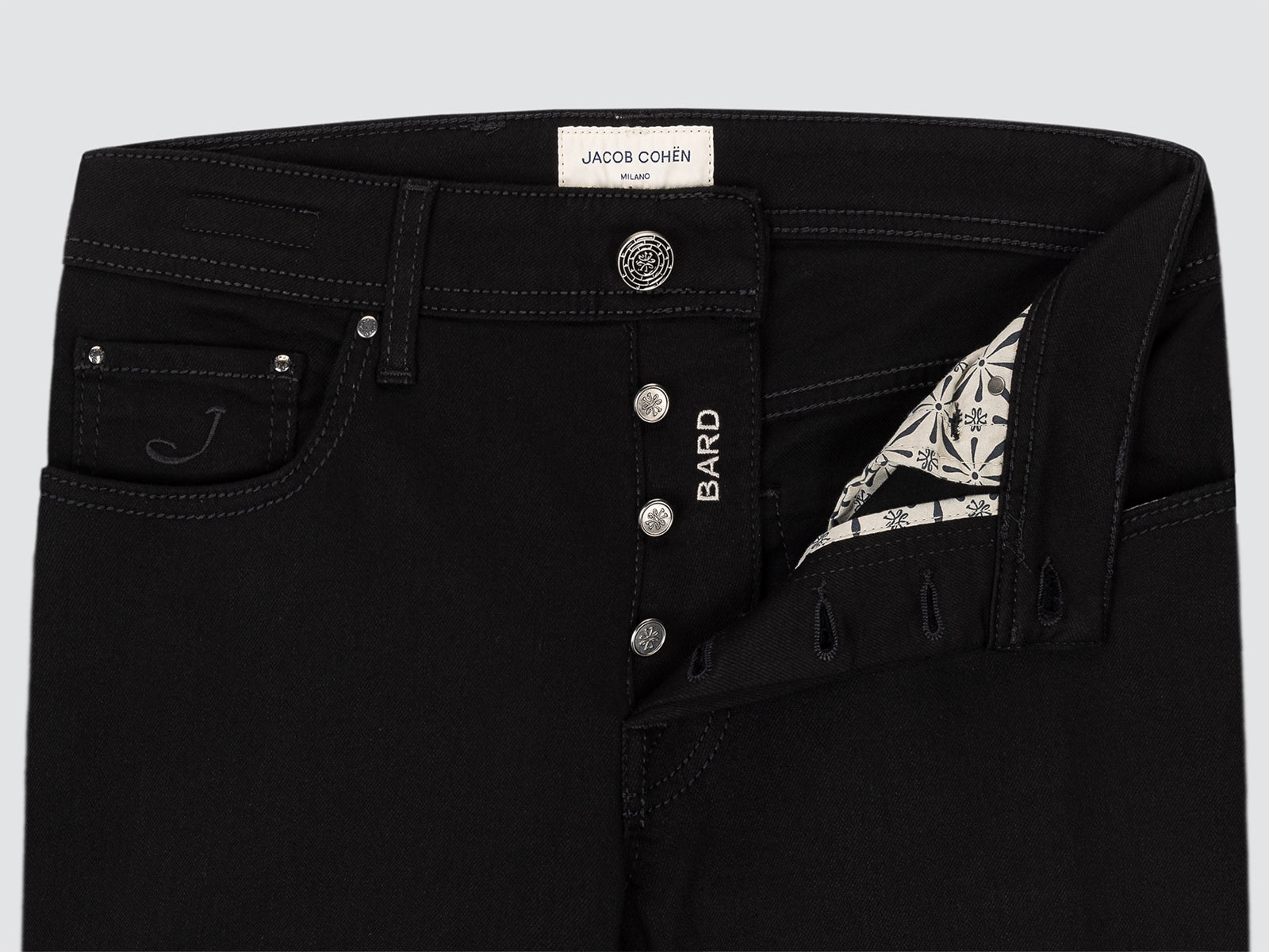 Black jeans with brand label on a light gray background