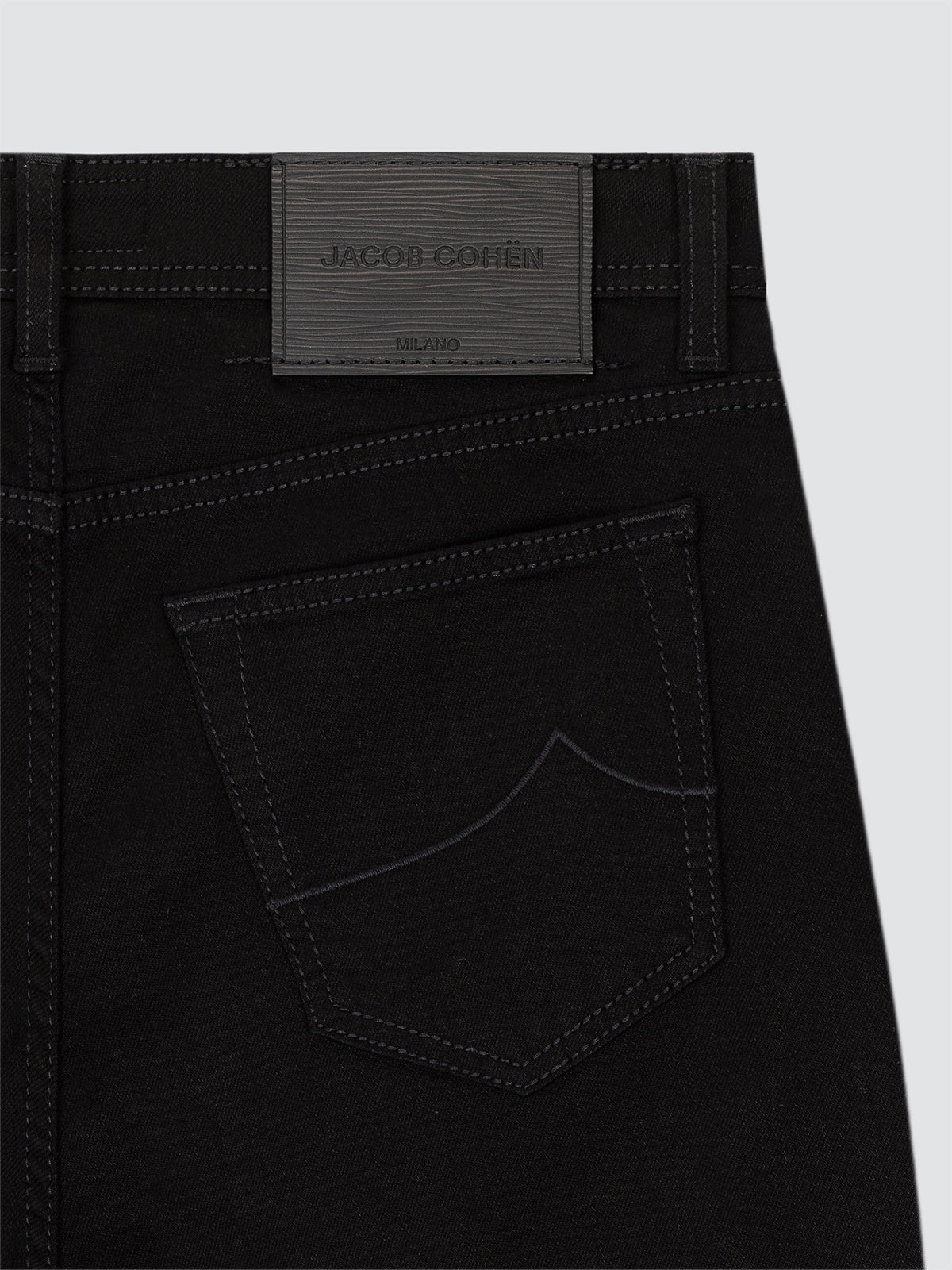 Black pants with a brand label on a light gray background