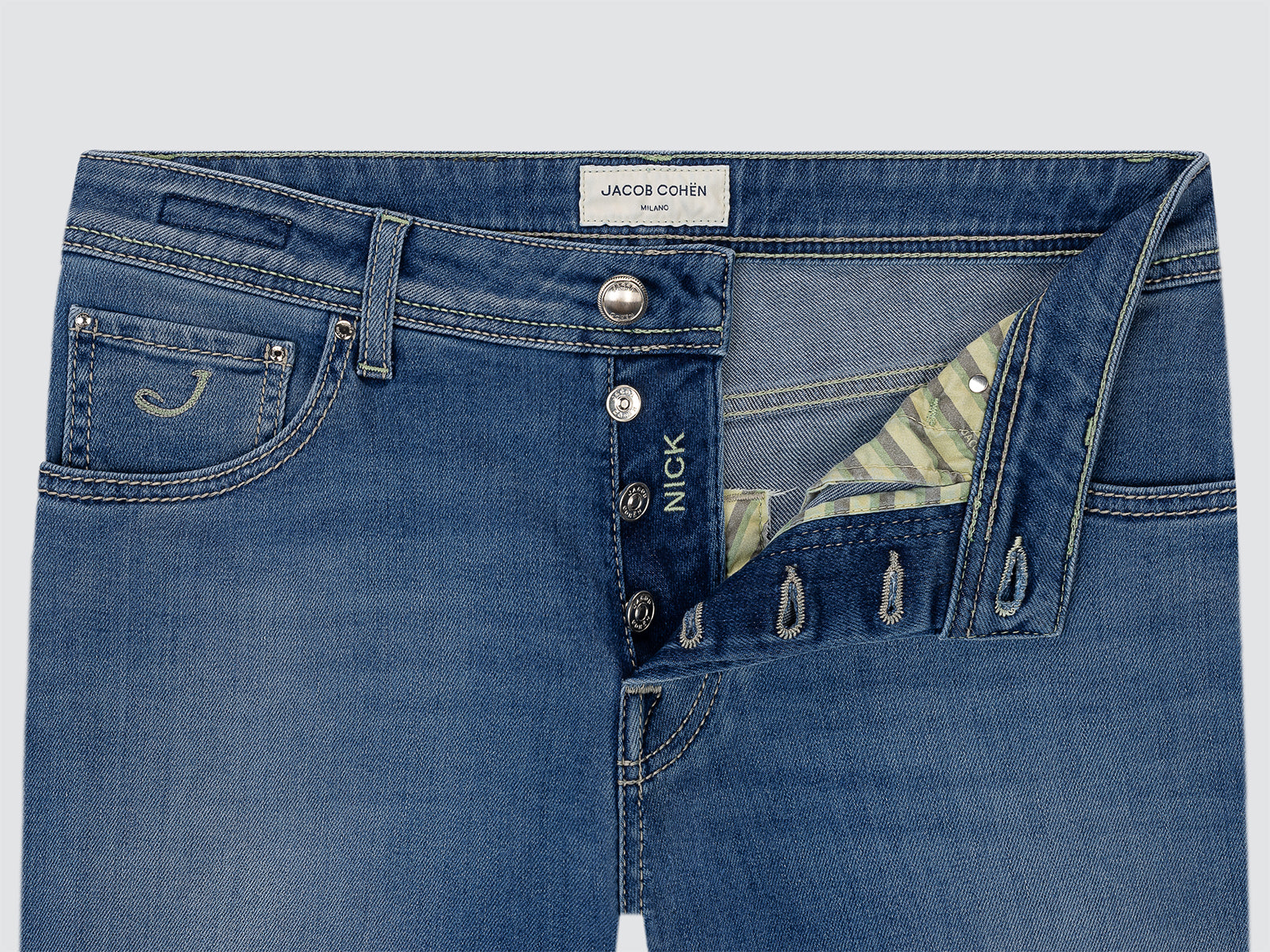 Close-up of blue jeans with visible branding on a light gray background