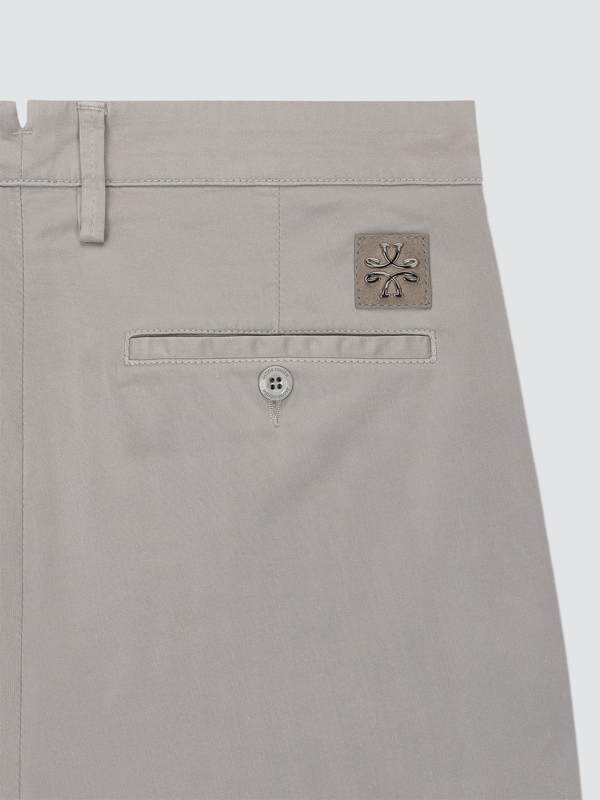 Close-up of a gray pants pocket with a brand logo Jacob Cohen  on a light gray background