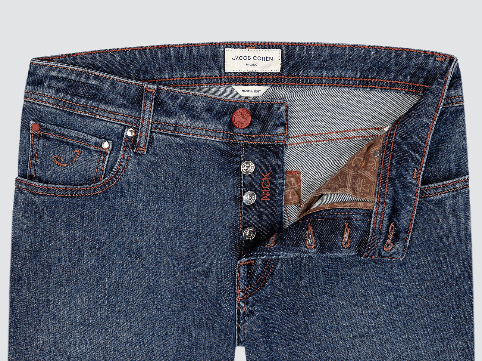 Close-up of blue jeans with visible branding on a light gray background
