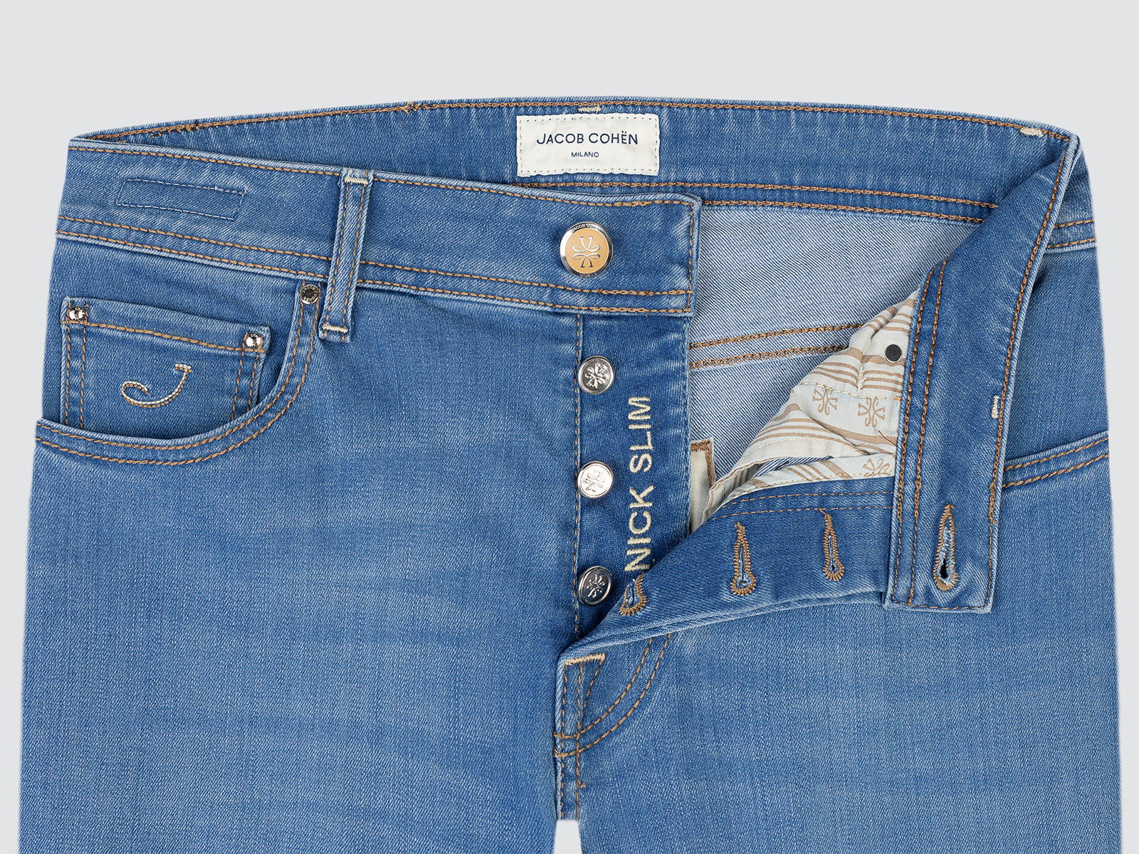 Close-up of blue jeans with visible branding on a light gray background