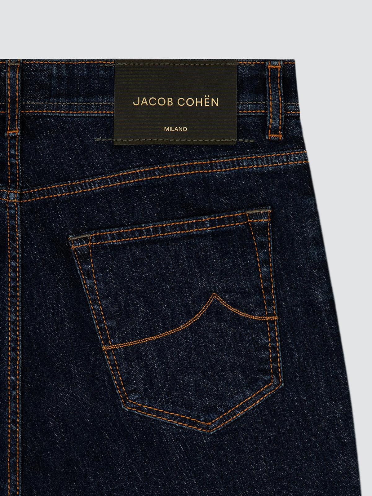 Dark blue indigo jeans Jacob Cohën bard with a small logo on a white background