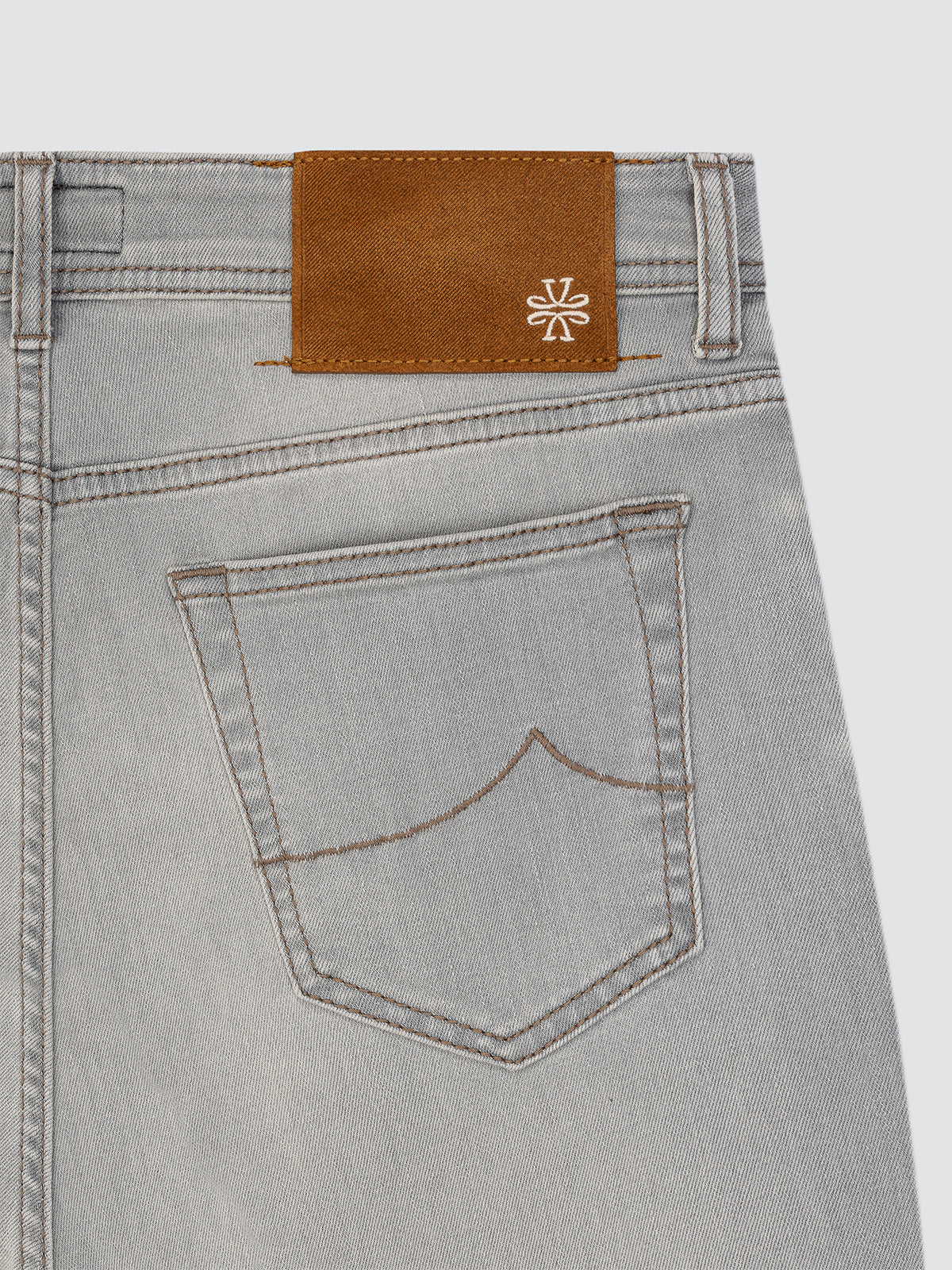 Gray jeans with a brown leather patch and brand logo Jacob Cohen on a light gray background