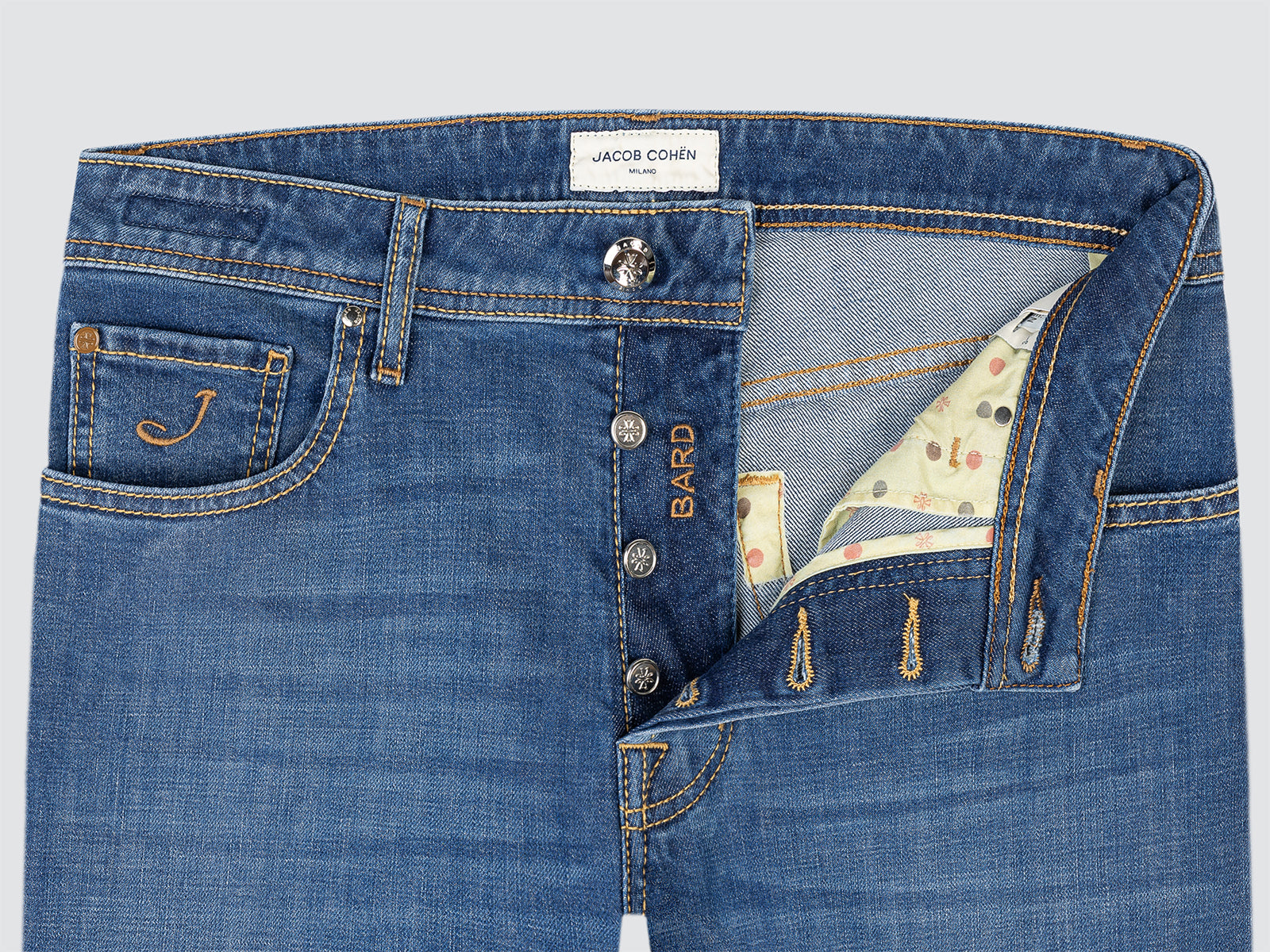 Close-up of blue jeans with visible branding on a light gray background