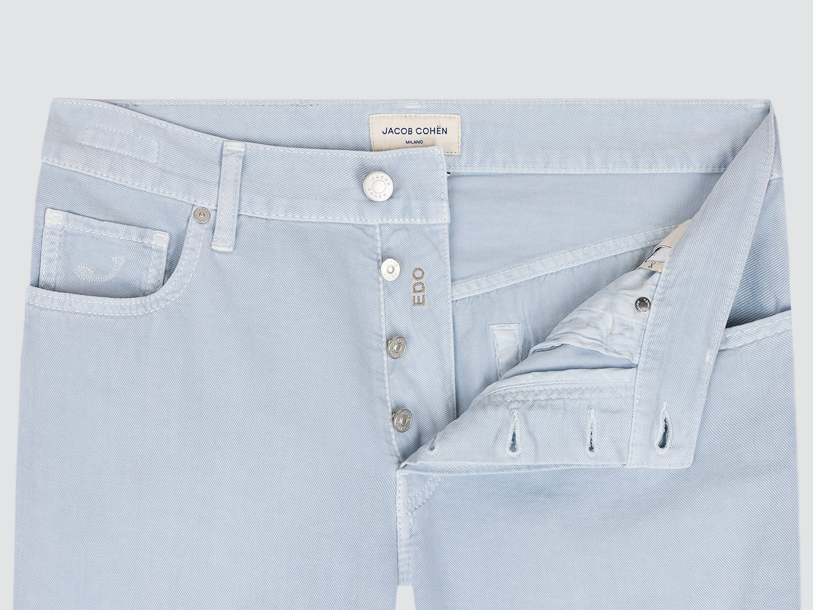 Light blue jeans with brand label on a light gray background