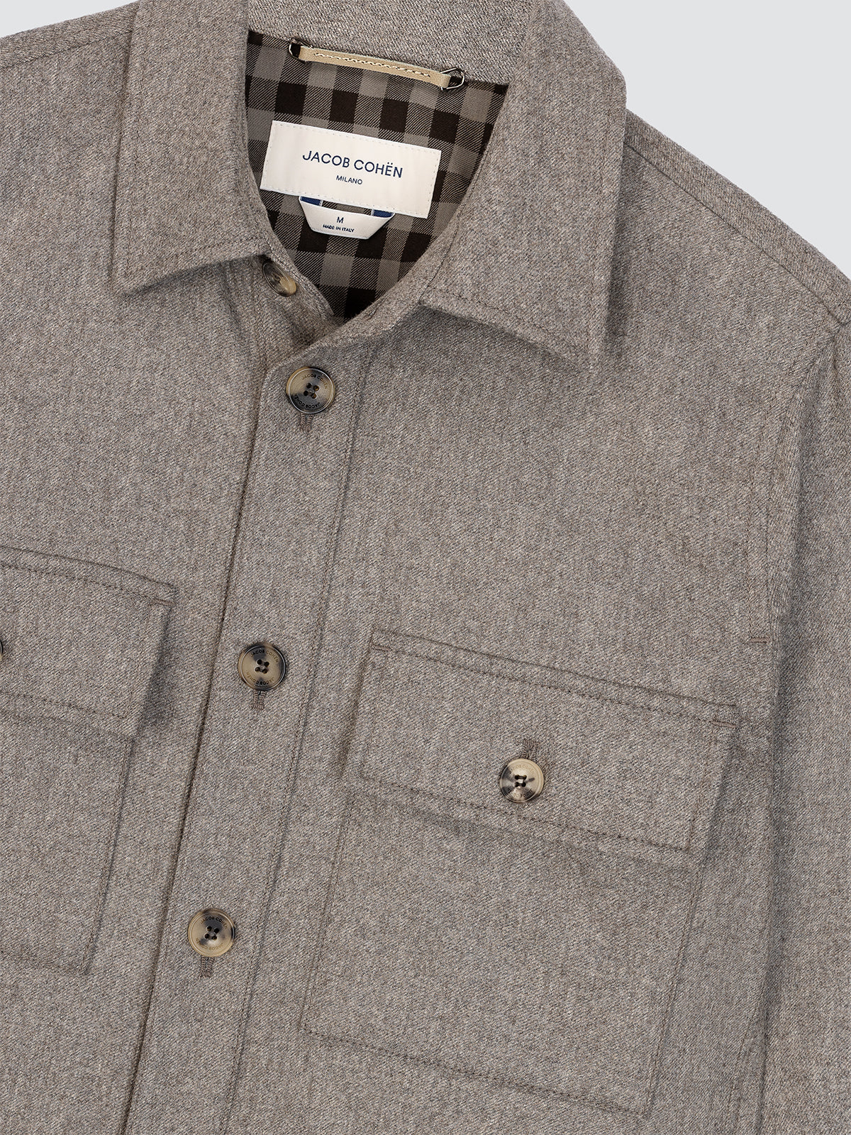 Gray jacket with plaid lining and 'Jacob  Cohen' label on a light gray background