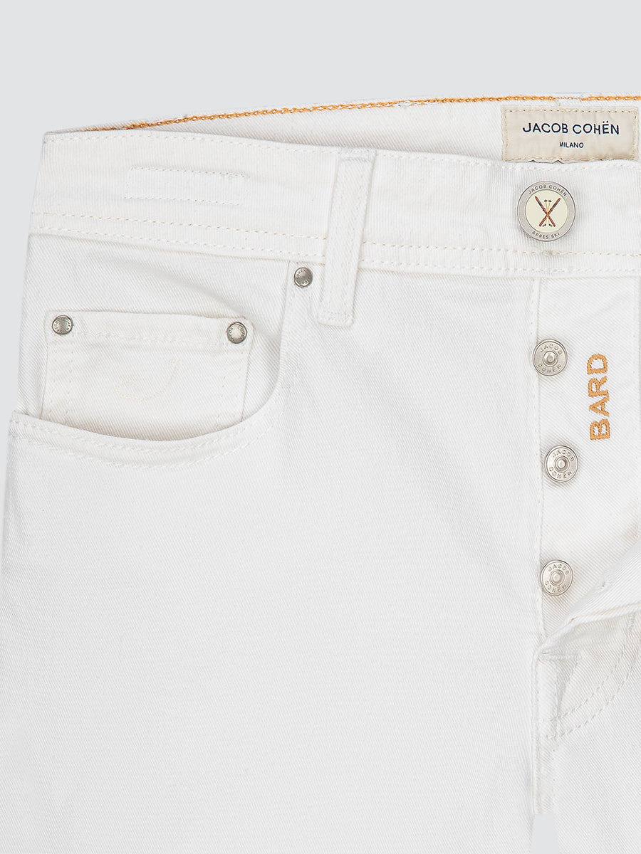 Close-up of white jeans with visible brand label on a white background