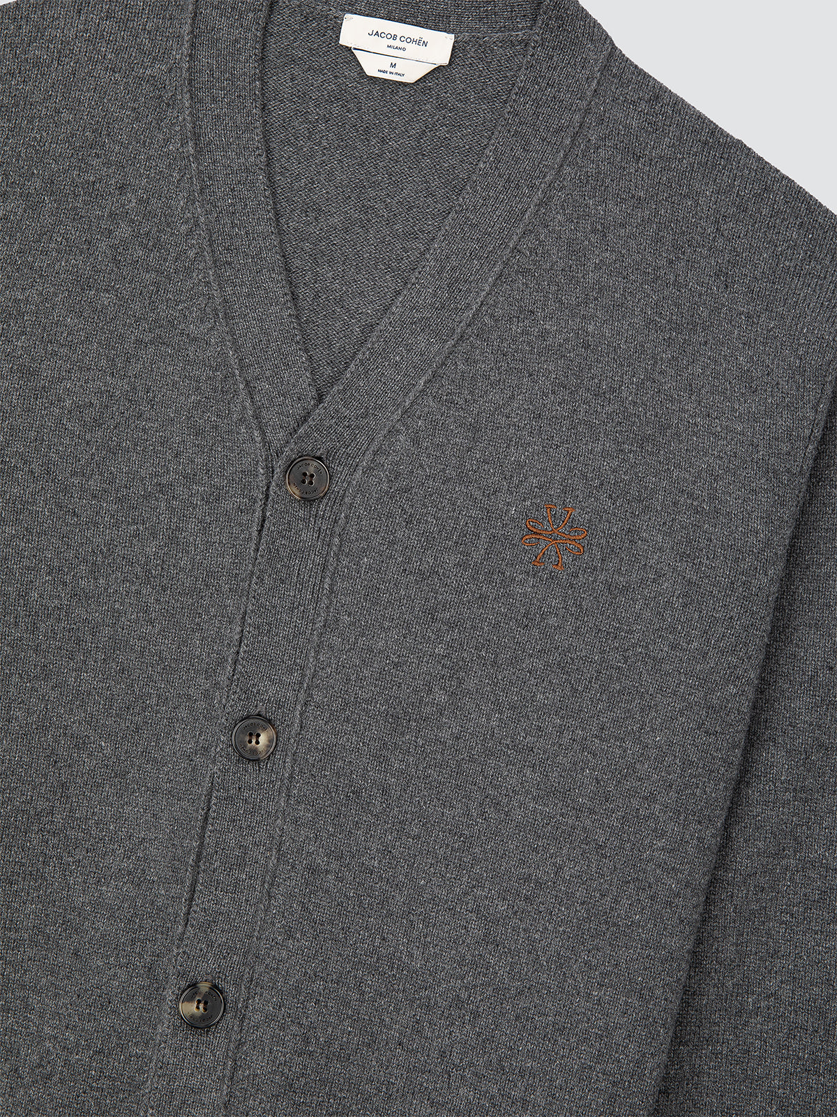 Gray cardigan with button details and a small logo on a light gray background