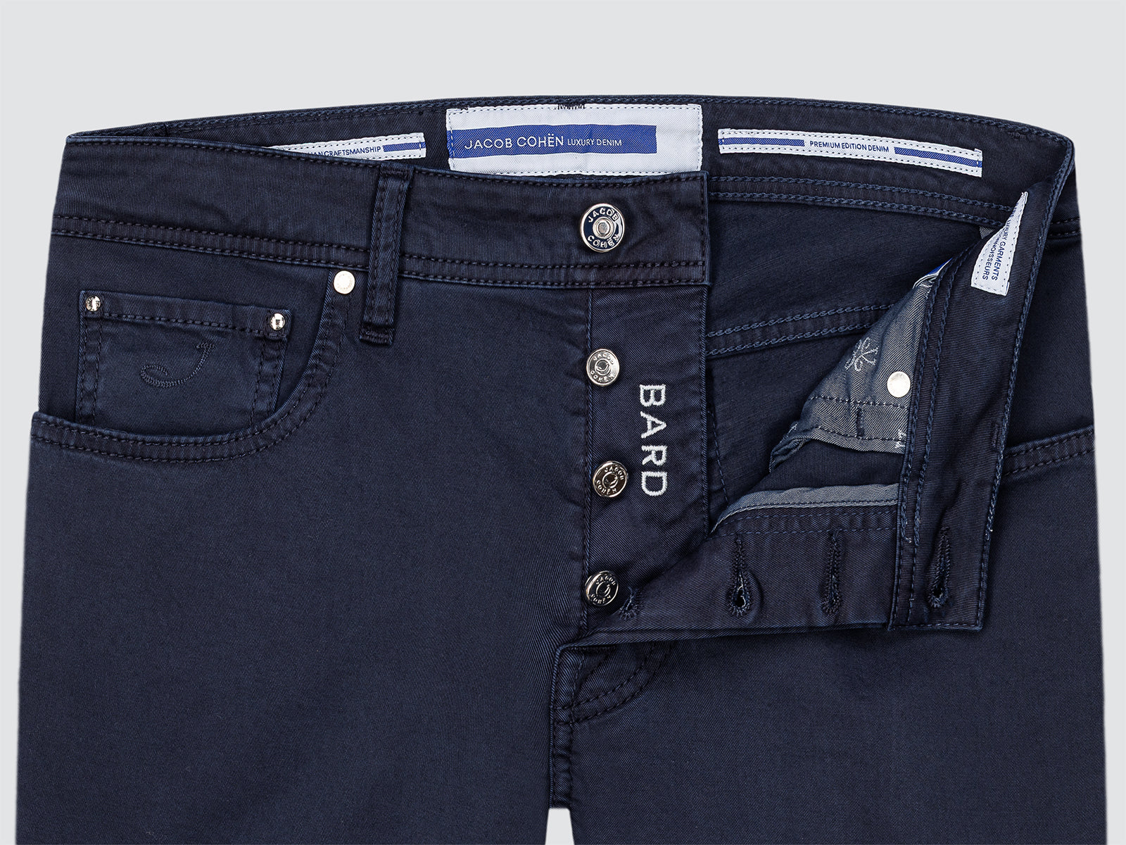 Navy blue pants with visible brand labels on a light gray background